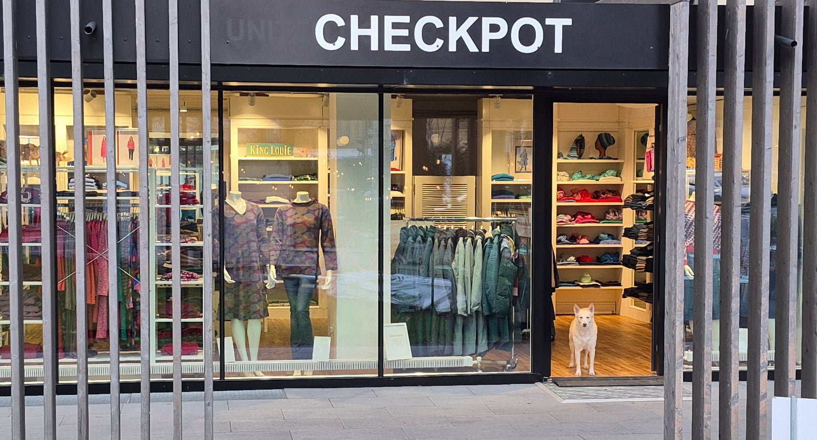 Schaufenster und Eingang der Checkpot Boutique in Wien-Hietzing mit Modedisplay und Boutique-Hund.